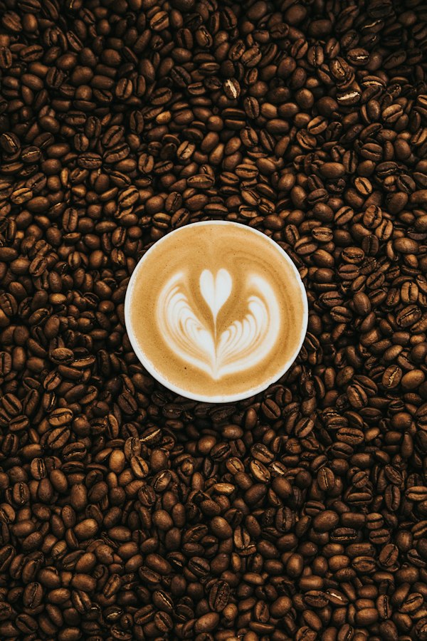Latte art coffee on roasted coffee beans